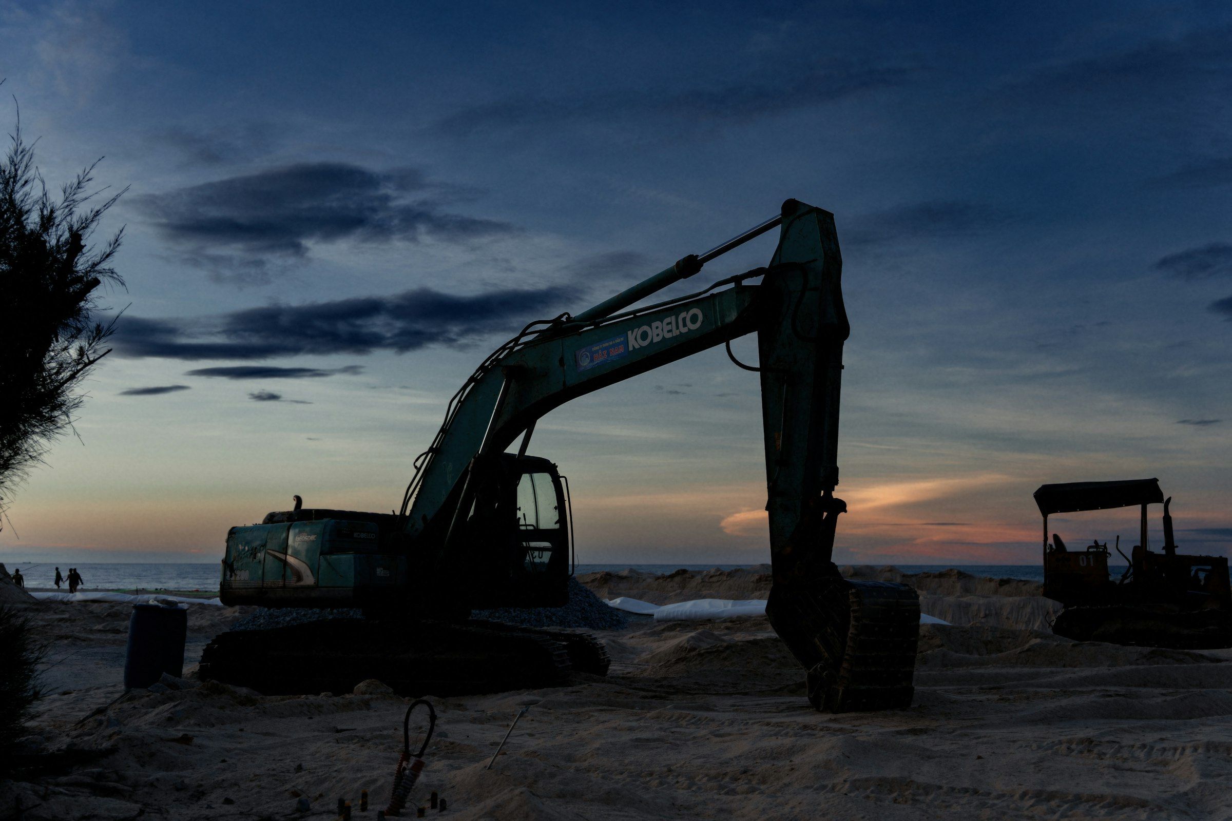 Silueta de una excavadora en una obra al atardecer